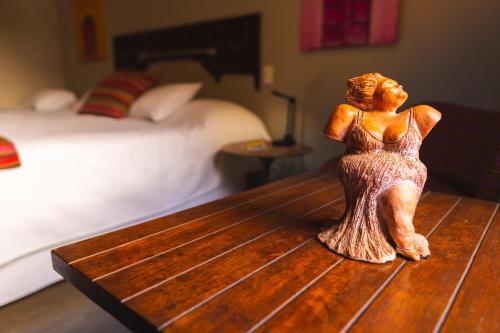 a figurine of a woman sitting on a table in a bedroom at Casa da Lua Pousada in Alto Paraíso de Goiás