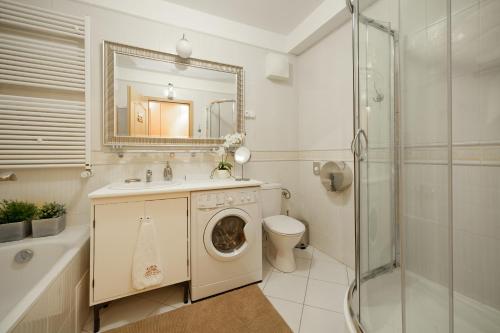 ein Badezimmer mit einem Waschbecken und einer Waschmaschine in der Unterkunft GDE Holló Apartments in Budapest