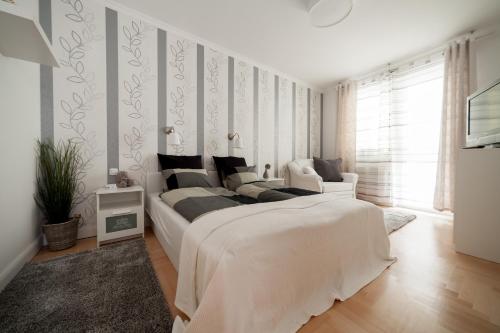 ein weißes Schlafzimmer mit einem großen weißen Bett. in der Unterkunft GDE Holló Apartments in Budapest