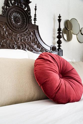 a red pillow sitting on top of a bed at Lugar do Ourives Boutique Hotel in Febres