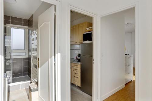 - une cuisine avec des murs blancs et des placards blancs dans l'établissement Le Nid du Roi - Appartement terrasse - Versailles, à Versailles