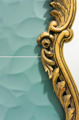 a gold mirror hanging on a wall at Lugar do Ourives Boutique Hotel in Febres