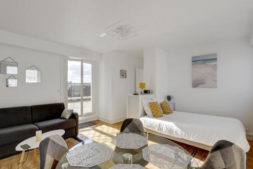 un salon avec un lit et un canapé dans l'établissement Le Nid du Roi - Appartement terrasse - Versailles, à Versailles