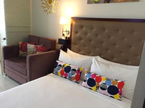 sypialnia z łóżkiem z krzesłem i kanapą w obiekcie Sky breeze haven w mieście Tagaytay