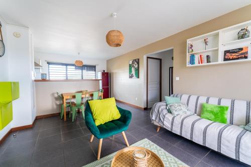 Hibiscus Standing- Appartement 2 chambres Cosy- Cuisine équipée- CLIM- WIFI-NETFLIX في كايان: غرفة معيشة مع أريكة وطاولة