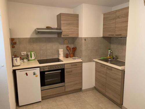 een kleine keuken met een fornuis en een koelkast bij Holiday Apartment in Nerezine