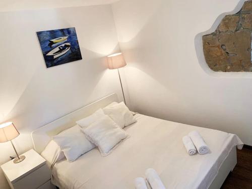 una piccola camera da letto con un letto bianco con due cuscini bianchi di Holiday Apartment a Nerezine (Neresine)