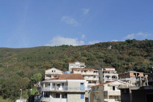 a group of houses in front of a mountain at Apartman Bećir in Budva