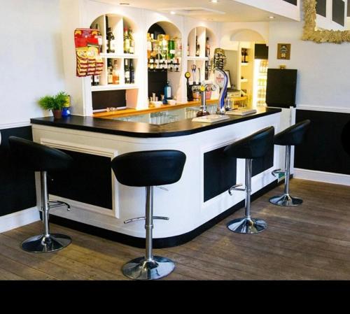 a kitchen with a bar with stools around it at The York Hotel in Wolverhampton