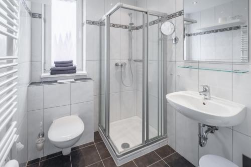 W łazience znajduje się prysznic, toaleta i umywalka. w obiekcie Michels Haus Kleine Auszeit w mieście Norderney