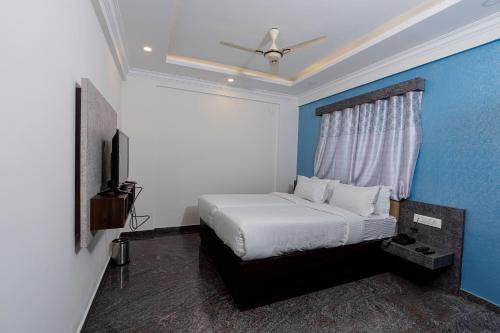 a bedroom with a bed and a ceiling fan at VALUE INN in Turuvekere