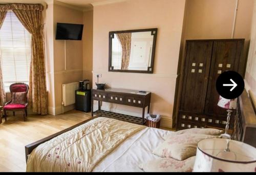 a bedroom with a bed and a desk and a mirror at The York Hotel in Wolverhampton