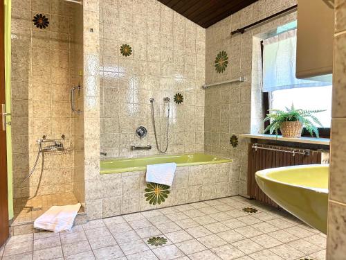 een badkamer met een bad en een wastafel bij Hohenwaldeck Seeblickrefugium in Schliersee