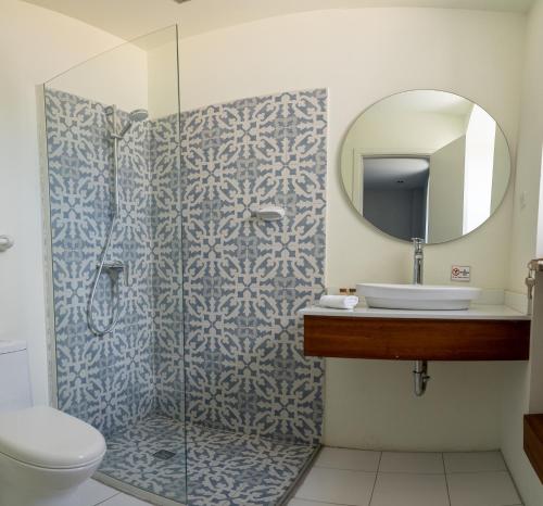 a bathroom with a shower with a sink and a mirror at CASA ANABELA HOTEL BOUTIQUE in Quito
