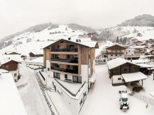 a snow covered town with buildings and a mountain at B&B Hotel Das Diellehen in Grossarl