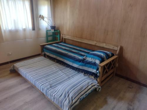 Cama en habitación con colchón a rayas en Casa en entorno de bosque, cerca de playas y cerros en San Carlos de Bariloche