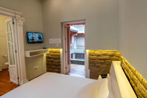 a bedroom with a bed and a stone wall at CASA ANABELA HOTEL BOUTIQUE in Quito