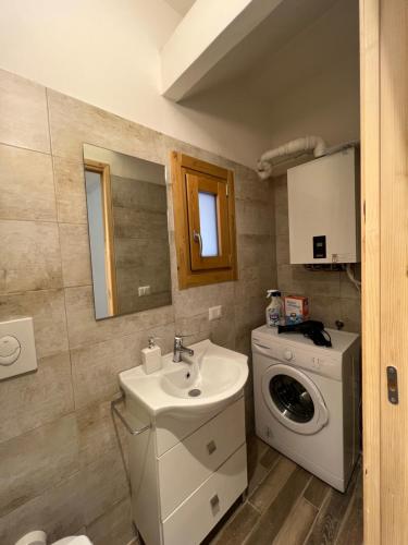 a bathroom with a sink and a washing machine at Casa vacanze “La baita” in Roccaraso