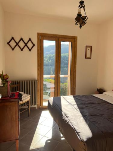 1 dormitorio con cama y ventana grande en Casa vacanze “La baita”, en Roccaraso