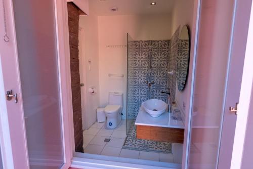 a small bathroom with a toilet and a shower at CASA ANABELA HOTEL BOUTIQUE in Quito