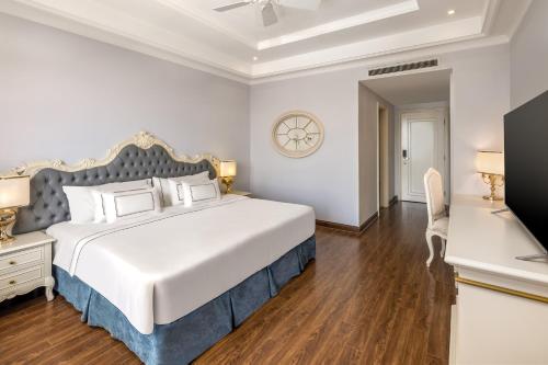 a bedroom with a large bed and a television at Melia Vinpearl Tay Ninh in Tây Ninh