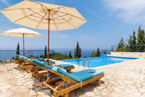 una piscina con sillas y sombrillas junto a una piscina en Sapphire Blue Villa, en Kalamitsi