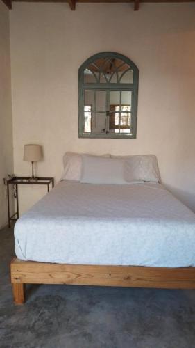 una camera da letto con un grande letto con uno specchio sul muro di Casa de Kai Mazunte a Mazunte