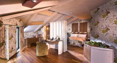 1 dormitorio con 1 cama y escritorio en una habitación en Il Boscareto Resort & Spa, en Serralunga d'Alba