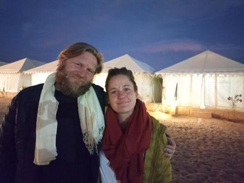Ein Mann und eine Frau stehen vor Zelten in der Unterkunft Night Stay Camp in Jaisalmer