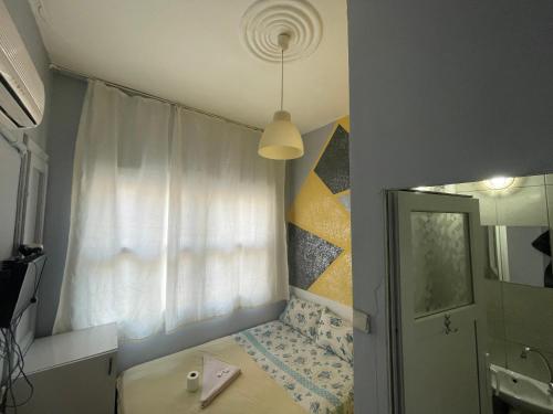 een kleine slaapkamer met een bed en een raam bij Ersoy Efe Pansiyon in Antalya