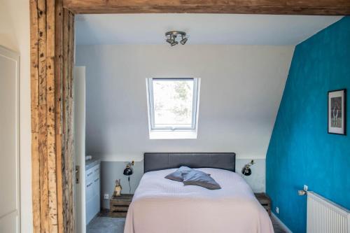 a bedroom with a bed with a blue wall at Im Schnuckenbau, Ferienhaus in Schneverdingen