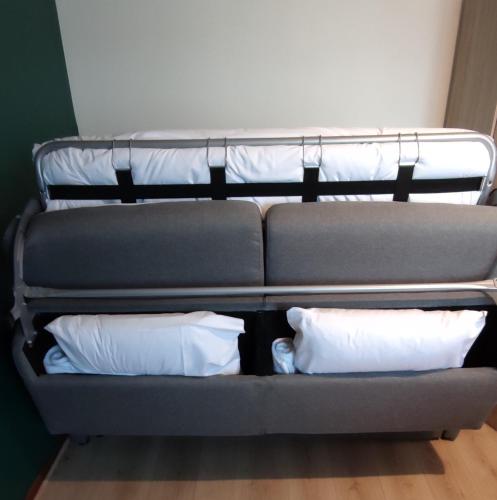 - un canapé avec deux oreillers dans l'établissement Studio Gare - Jardin des Plantes - wifi & calme, à Nantes