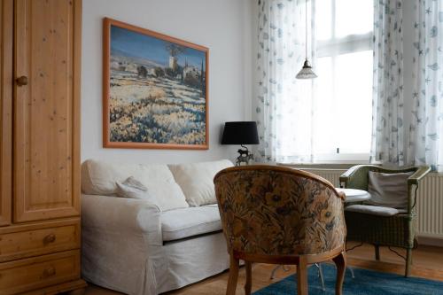 a living room with a white couch and a chair at Aparthotel Domizil in Borkum