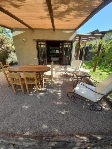 un patio con mesa de madera y sillas en Loft Vistalba en Mendoza