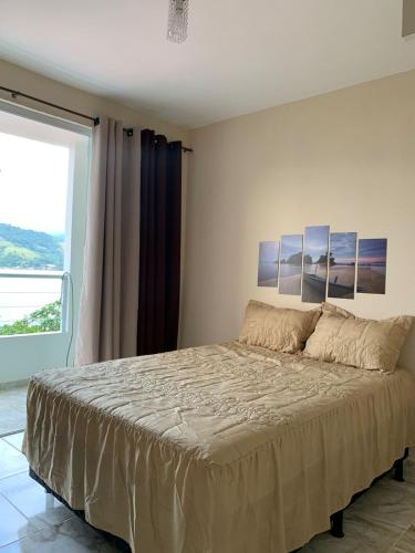 a bedroom with a large bed in front of a window at Casa com Praia no quintal in Angra dos Reis