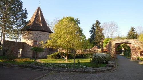 a stone building with a tower and an archway at Gîte, Maison indépendante "Chez Yvette et André" 2 à 6 pers, Ribeauvillé à 3 km, Colmar à 10 km in Guémar