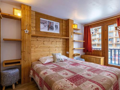 a bedroom with a bed and a wooden wall at Appartement Val-d'Isère, 2 pièces, 4 personnes - FR-1-694-234 in Val-d'Isère