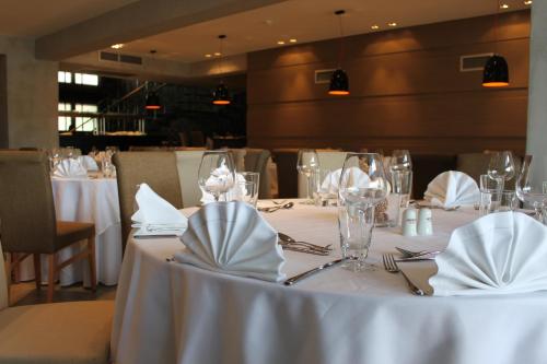 a table with white table cloths and napkins on it at Anatolia Hotel Komotini in Komotini