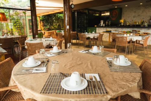 a table with plates and napkins on it in a restaurant at Casa da Lua Pousada in Alto Paraíso de Goiás