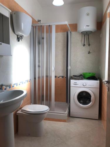 a bathroom with a toilet and a washing machine at Pizzo Beach Club by Maralp in Pizzo