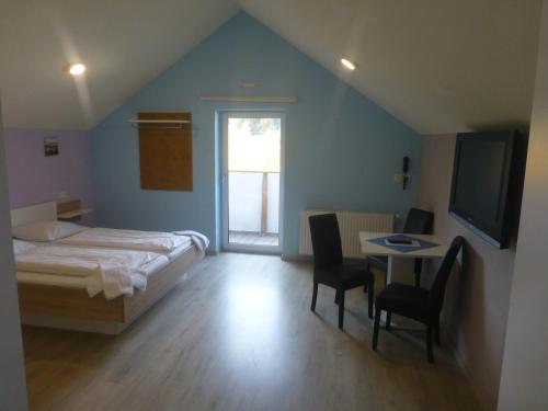 1 dormitorio con 1 cama, mesa y sillas en ROSSLWIRT-Rast en Strass im Attergau