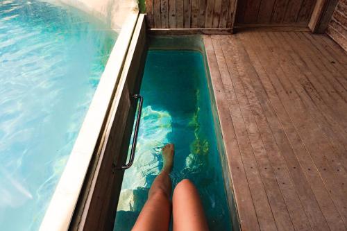 a person in a swimming pool with their feet in the water at Casa da Lua Pousada in Alto Paraíso de Goiás