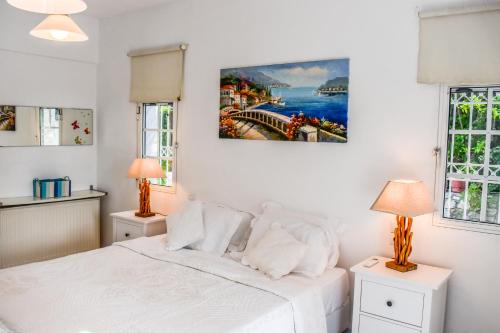 1 dormitorio con 1 cama blanca y 2 lámparas en View Villas en Punta