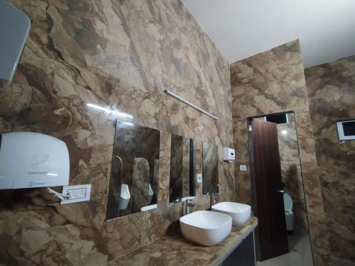 a bathroom with two sinks and a stone wall at Flamingo Club and Resort Una 3 Km Away from Diu Check Post in Diu
