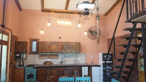 a kitchen with wooden cabinets and a counter top at Casa de Campo, con Pileta y Asador Criollo!! - "La Ranchada" in Gualeguaychú