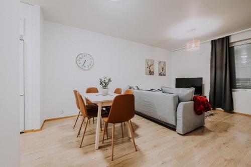 ein Wohnzimmer mit einem Tisch und einem Sofa in der Unterkunft Apartment, SleepWell, Tyynimeri with private parking and optional private sauna in Helsinki