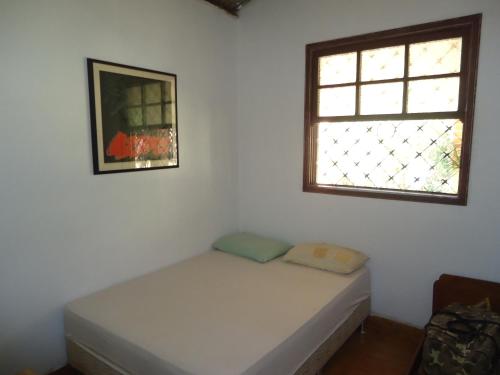 a bed in a room with a window at Estalagem das Estrelas in Cristalina