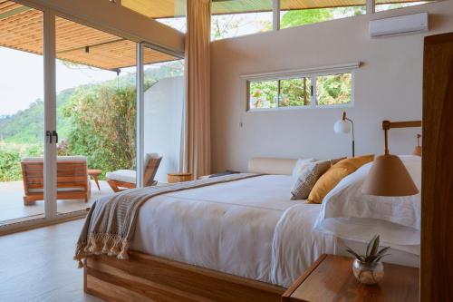 a bedroom with a bed and a large window at Vista Celestial in Uvita