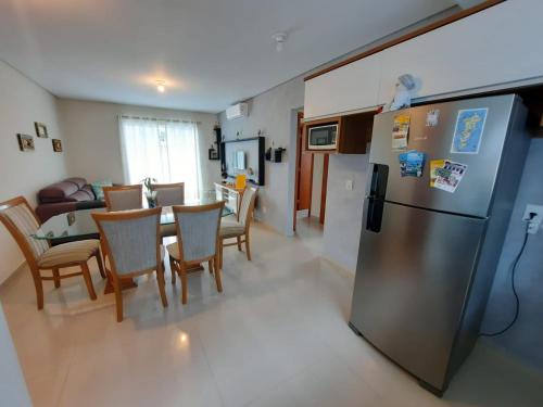 een keuken en eetkamer met een tafel en een koelkast bij Apartamento Novo Norte da Ilha in Florianópolis