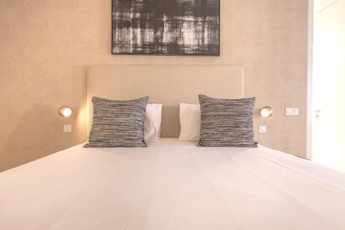 a large white bed with two pillows on it at Ando Living - Douradores House in Lisbon